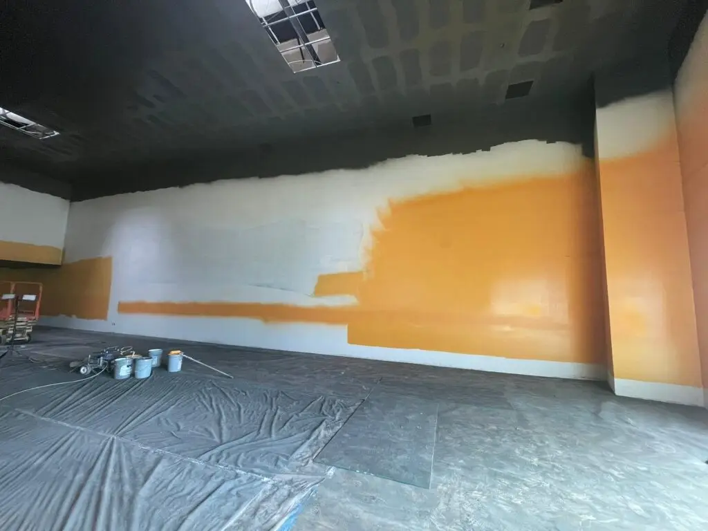 unfinished wall paint with buckets of paint