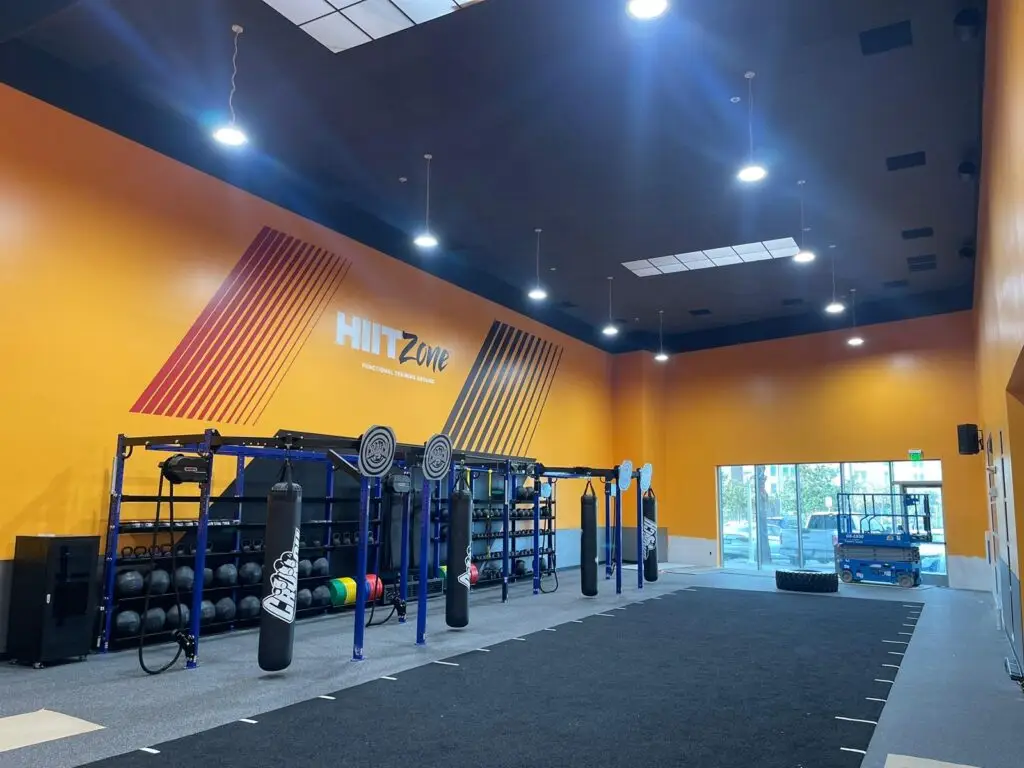 interior of a fitness gym with big yellow wall and equipment